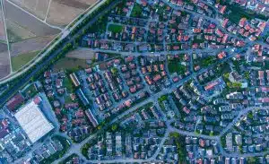 Luftaufnahme eines Wohngebiets mit Einfamilien- und Reihenhäusern mit roten Dächern und Gärten
